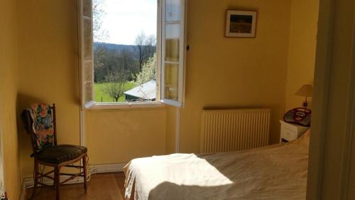 une chambre avec un lit, une fenêtre et une chaise dans l'établissement Charming house in Périgord Vert, à Saint-Félix-de-Villadeix