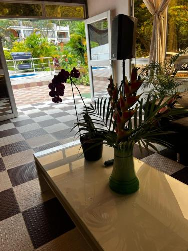 a table with a vase with flowers on it at Finca de descanso Brisas de Calandaima in Viotá