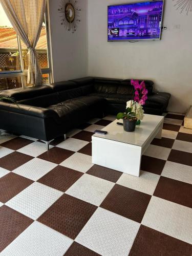 a living room with a black leather couch and a coffee table at Finca de descanso Brisas de Calandaima in Viotá