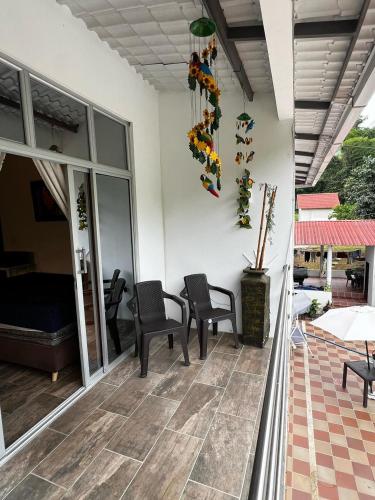 a patio with two chairs and a room with at Finca de descanso Brisas de Calandaima in Viotá