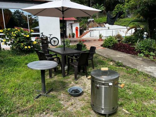 a trash can next to a table with an umbrella at Finca de descanso Brisas de Calandaima in Viotá