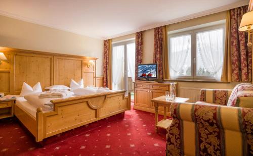 a hotel room with a bed and two chairs at Naturhotel Alpenblick in Maurach