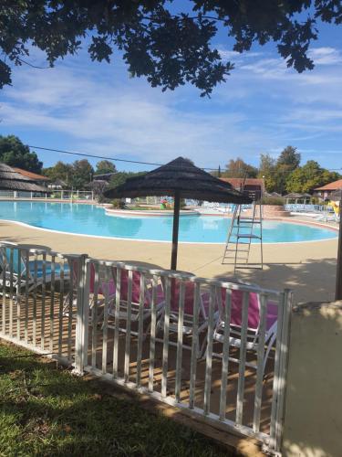 - une table et des chaises avec un parasol en face de la piscine dans l'établissement Détente et Lac, à Gastes