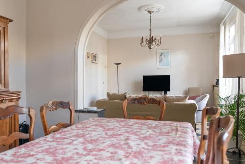 ein Wohnzimmer mit Tisch und Couch in der Unterkunft Villa Maurel YourHostHelper in Arles
