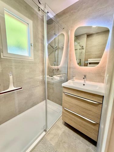 une salle de bain avec une douche, un lavabo et un miroir dans l'établissement stunning sea view, à Cavalaire-sur-Mer