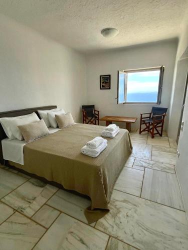 a bedroom with a large bed with towels on it at Olea Tinos, A Luxury Villa in Kardiani