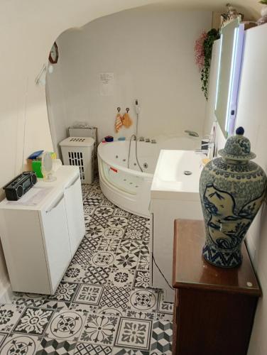 a bathroom with a bath tub and a vase on a table at La ruelle in Volonne