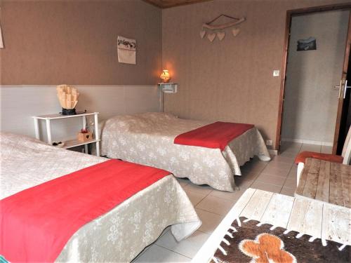 une chambre d'hôtel avec deux lits et une table dans l'établissement La Cévane, à Chorges