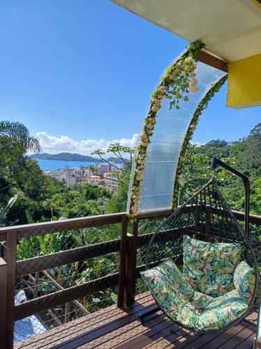 a swing on a deck with a view of the ocean at Suíte Amazônia in Bombinhas