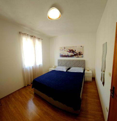 a bedroom with a blue bed and a window at Apartman Ivo, Bol in Bol