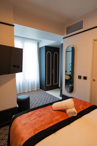 a hotel room with a bed and a large mirror at Hôtel et Restaurant Le Regina in Le Puy en Velay