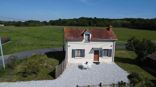 ein kleines weißes Haus mitten auf einem Feld in der Unterkunft MA SOLOGNE,ZOO BEAUVAL,CHATEAUX DE LA LOIRE,GOLF in Sassay