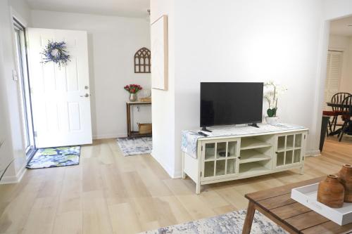 a living room with a flat screen tv on a cabinet at 3 Bedroom Lake House With Garage in Tallahassee