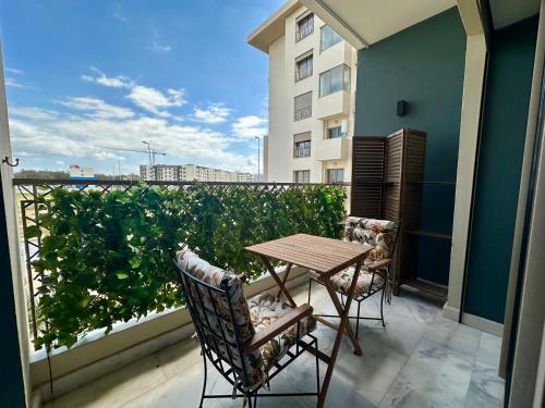 a balcony with a table and chairs and a building at AeroRelax, free Parking, WI-FI in Nouaseur