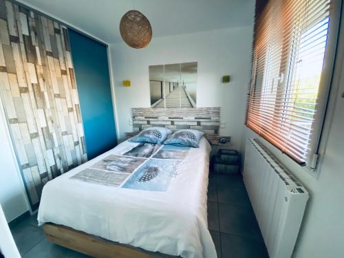 une chambre avec un lit et une grande fenêtre dans l'établissement Appartement T2, 5mn à pied de la plage et du port de Sanary, à Six-Fours-les-Plages