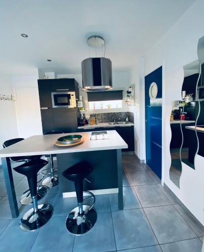 - une cuisine avec une table et des tabourets dans l'établissement Appartement T2, 5mn à pied de la plage et du port de Sanary, à Six-Fours-les-Plages
