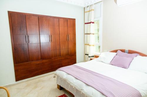 a bedroom with a large wooden cabinet and a bed at Dar Rouissi in Tozeur