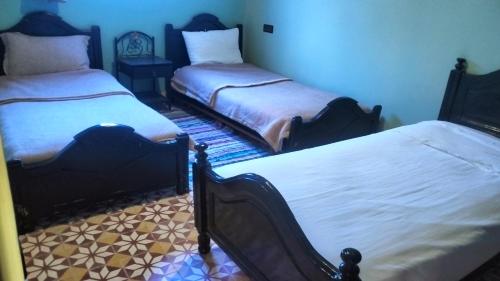 two beds sitting in a room with at Kasbat Taslit chez l'habitant in Tabount