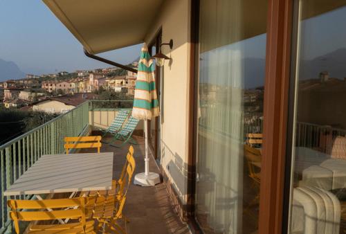 a balcony with a table and chairs and an umbrella at HomeTerra in Brenzone sul Garda