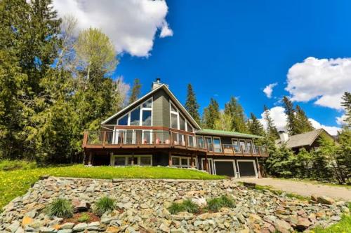 a large house on a hill with a stone yard at Dog friendly Home on Ski Hill with Hot Tub by StayIn in Fernie