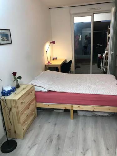 une chambre avec un lit et un bureau avec une lampe dans l'établissement Jardin de Paris proche de métro 15 -25 minutes à Musée de Louvre magasin galeries Lafayette Gare Saint Lazare Châtelet Gare de Lyon, à Gennevilliers