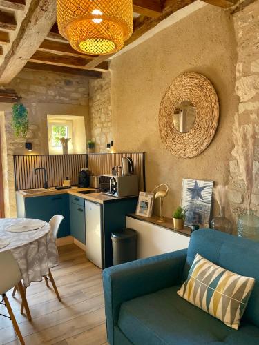 un salon avec un canapé bleu et une cuisine dans l'établissement Domaine des Varennes, à Louresse-Rochemenier