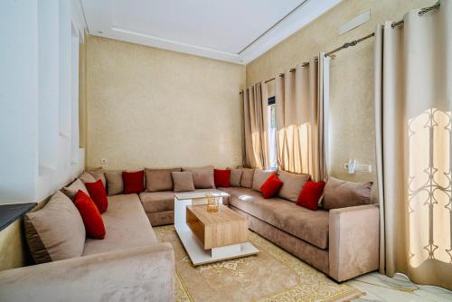 a living room with a large couch and red pillows at Villa Nadia Marrakech in Marrakech