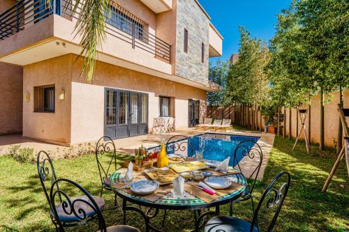 a table and chairs in front of a house at Villa Nadia Marrakech in Marrakech