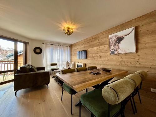 une salle à manger avec une table et des chaises en bois dans l'établissement Homency - Résidence L'Expression D21, à L'Alpe-d'Huez