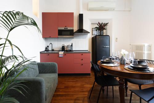 a living room with a table and a kitchen at In Piazza 'Apartments & Relax' in Ravenna