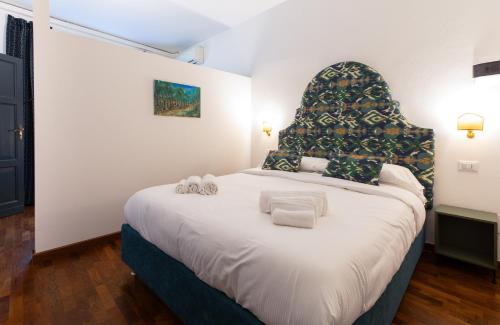 a bedroom with a large bed with towels on it at In Piazza 'Apartments & Relax' in Ravenna