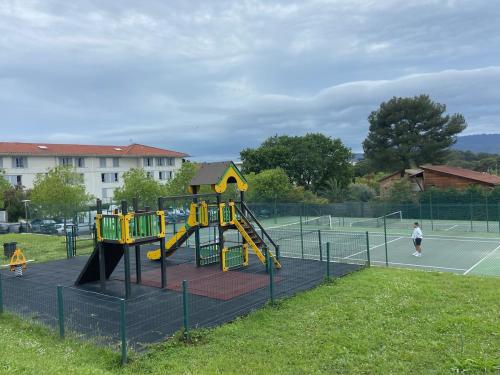 a playground with a slide on a tennis court at 2P jardin Sud vue Lac avec piscine tennis parking privé in Le Cannet