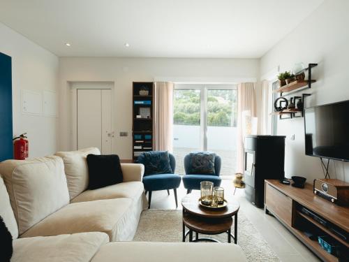 a living room with a couch and a tv at Cazenn Salir do Porto - Holiday house in Salir de Porto