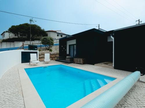 a swimming pool in the backyard of a house at Cazenn Salir do Porto - Holiday house in Salir de Porto