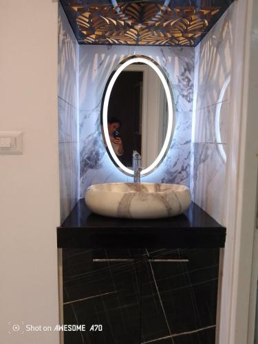 a bathroom sink with a round mirror on a counter at Jasmine in Bin Rhilouf