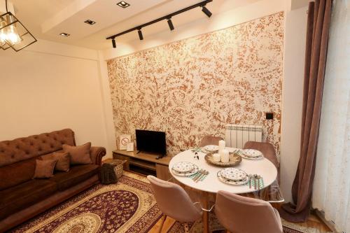 a living room with a table and a couch at Apartman MERY centar Novi Pazar in Novi Pazar
