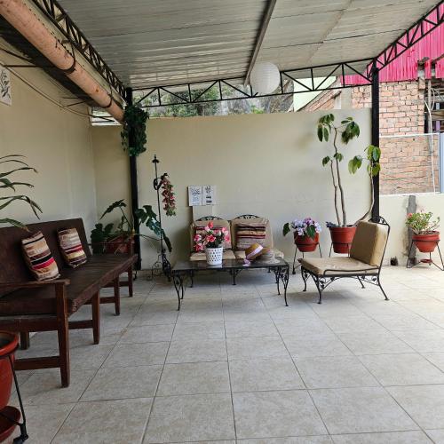 a patio with benches and potted plants in a room at Hotel Acuario in Churín