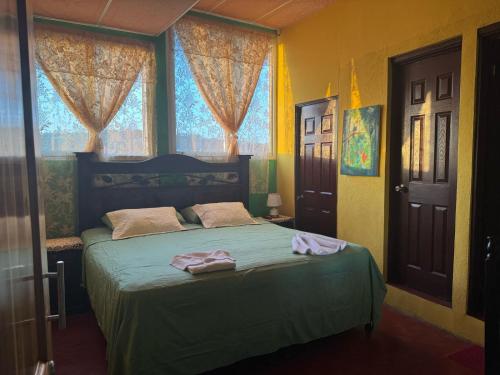フローレスにあるCasa Maya Itzaのベッドルーム1室(緑のシーツと窓付)