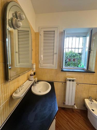 a bathroom with two sinks and a mirror at Bilocale Voltri Mare 4 posti in Genova