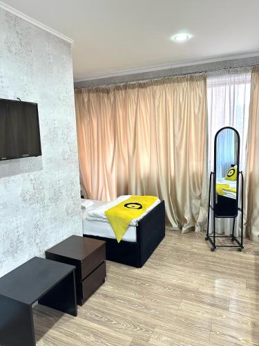 a bedroom with a bed and a chair in it at Aura Plaza Hotel in Tbilisi City