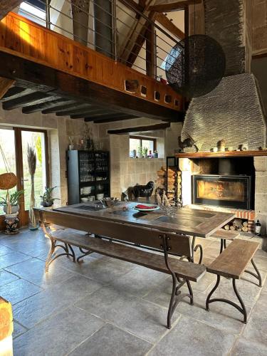 une grande cuisine avec une grande table et une cheminée dans l'établissement Les Alpagas de La Tuilerie , 3 Chemin de la Tuilerie, à Batilly-en-Puisaye