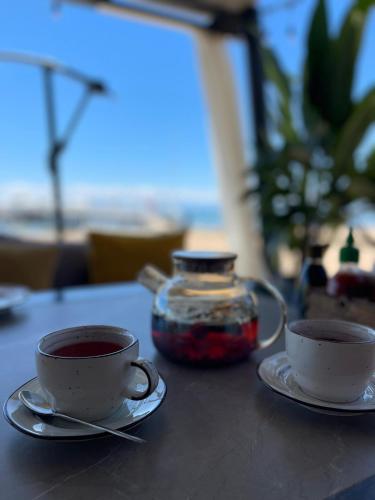 two cups of tea and a jar on a table at Квартира на Иссык-куле в ЦО Радуга in Chon-Sary-Oy