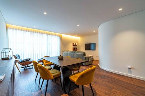 a living room with a table and chairs and a couch at Boavista Serralves Family House in Porto