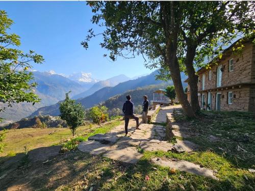 dos personas caminando por un camino cerca de un edificio en Chaukhamba Cradle, en Ukhimath
