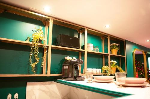 une cuisine aux murs verts et un comptoir avec de la vaisselle dans l'établissement L'Instant Boudoir - Parenthèse élégante à Rouen, à Rouen