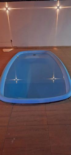 a blue tub sitting on top of a wooden floor at Casa completa com área gourmet e piscina -2 quartos in Macapá