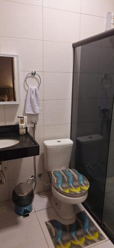 a bathroom with a toilet and a sink and a shower at Casa completa com área gourmet e piscina -2 quartos in Macapá
