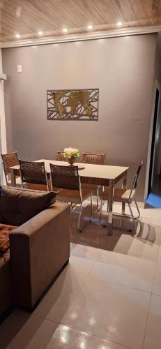 a dining room with a table and chairs and a couch at Casa completa com área gourmet e piscina -2 quartos in Macapá