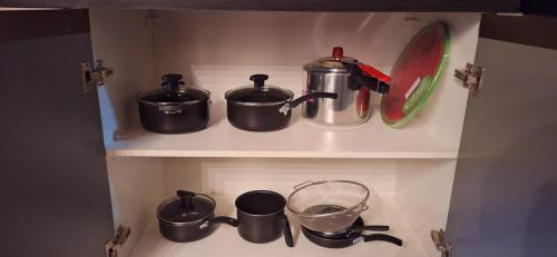 a kitchen shelf with pots and pans and a mixer at Casa completa com área gourmet e piscina -2 quartos in Macapá