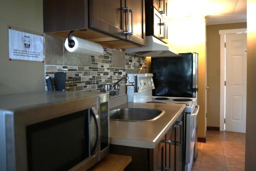 a kitchen with a sink and a stove at Malahat Bungalows Motel in Malahat